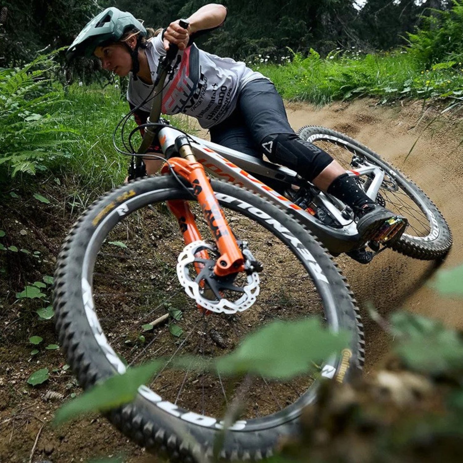 Female mountainbiker riding pivot firebird silver sunrise with fox forks on downhill track