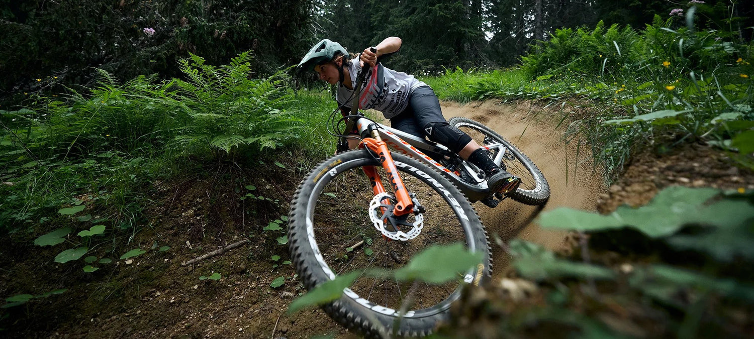 Female mountainbiker riding pivot firebird silver sunrise with fox forks on downhill track